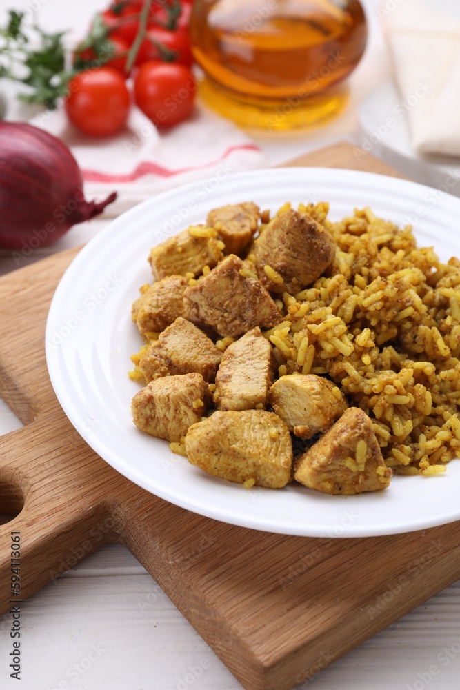 Plate of delicious rice with chicken on white wooden table, closeup Plate of delicious rice with chicken on white wooden table, closeup