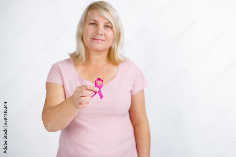 Woman in pink sweater with pink ribbon supporting breast cancer awareness campaign. Woman in pink sweater with pink ribbon supporting breast cancer awareness campaign.