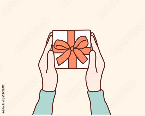 Womans hands holding gift or present box decorated confetti on yellow pastel table top view.Hand drawn style vector design illustrations.