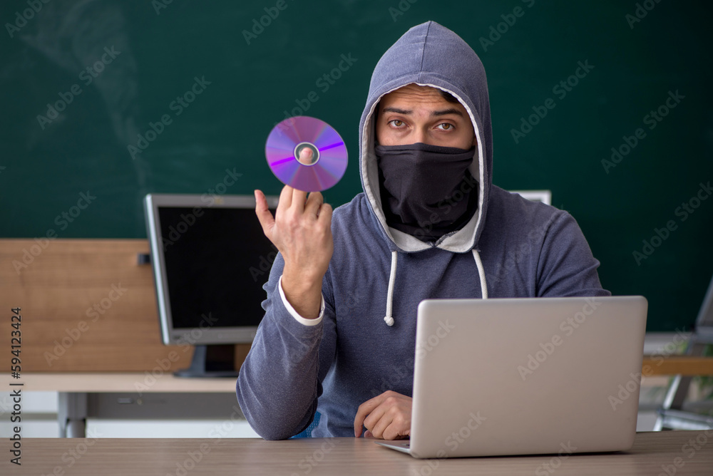 Young male hacker sitting in the classroom Young male hacker sitting in the classroom
