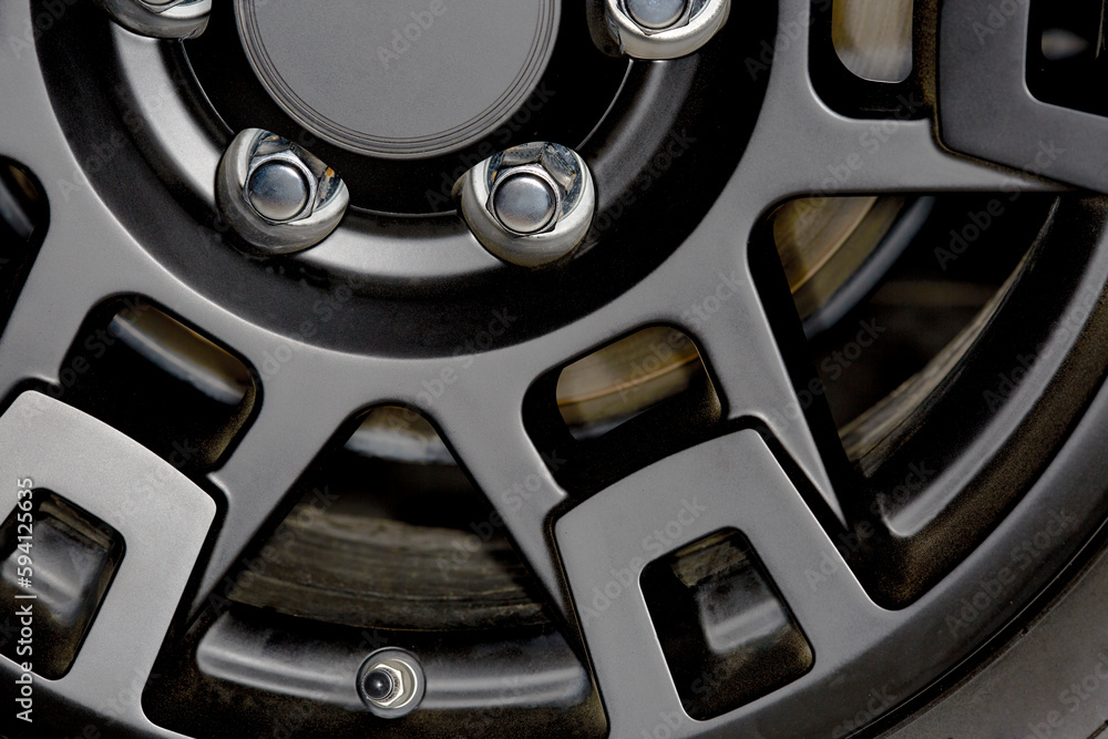 Close up of a Black Car Wheel Rim with Chrome Lug Nuts Close up of a Black Car Wheel Rim with Chrome Lug Nuts