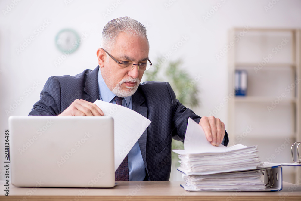 Old male employee working in the office Old male employee working in the office