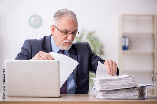 Old male employee working in the office