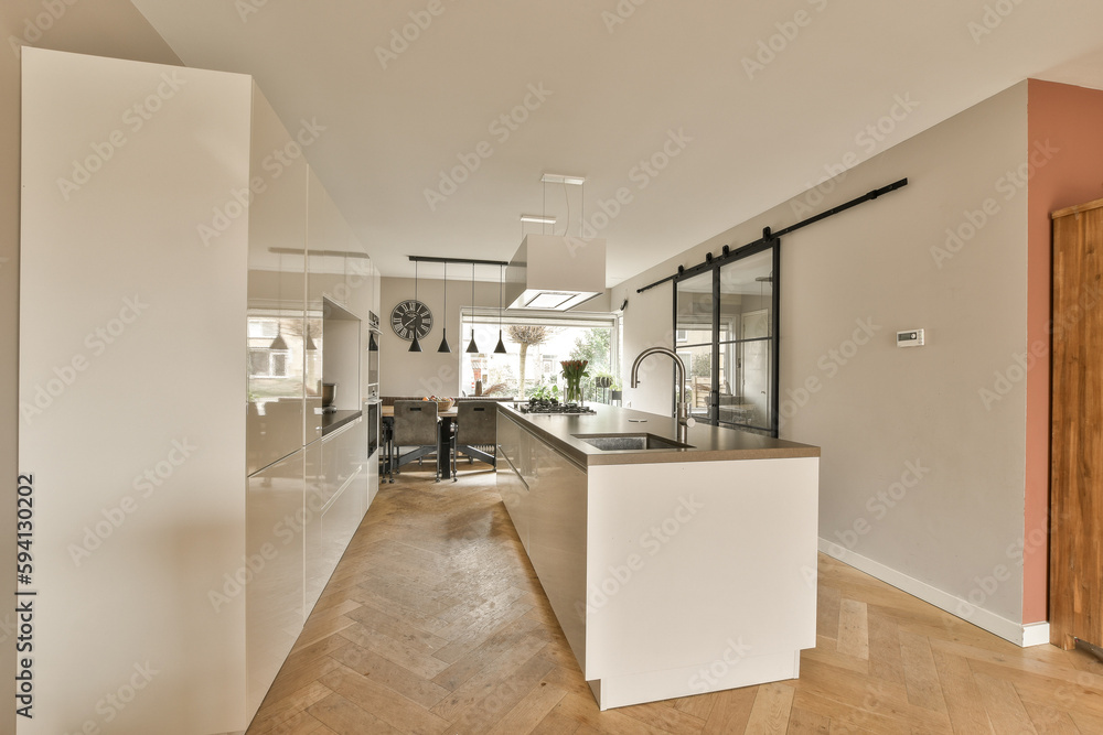a kitchen and dining area in a house with wood flooring, white walls and an open door leading to the living room a kitchen and dining area in a house with wood flooring, white walls and an open door leading to the living room