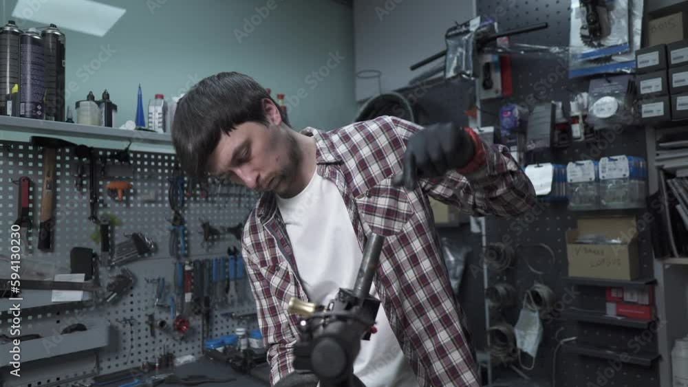 Male mechanical engineer, repairman repairs mechanical damage to wheel of children scooter. Small business for service and maintenance of ecological transport of scooters. Broken kick e scooter. Male mechanical engineer, repairman repairs mechanical damage to wheel of children scooter. Small business for service and maintenance of ecological transport of scooters. Broken kick e scooter.