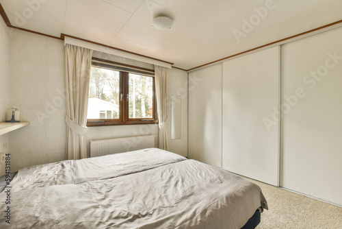 a bedroom with a bed and closets in the corner next to the window that looks out onto the street