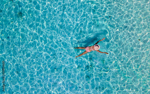 drone view at a woman swimming in the blue turqouse colored ocean of Koh Kradan island in Thailand