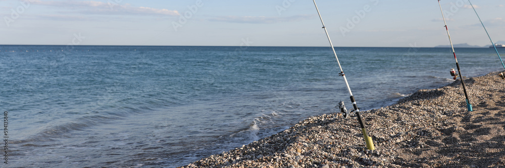 Fishing rods on sea beach, seaside landscape Fishing rods on sea beach, seaside landscape