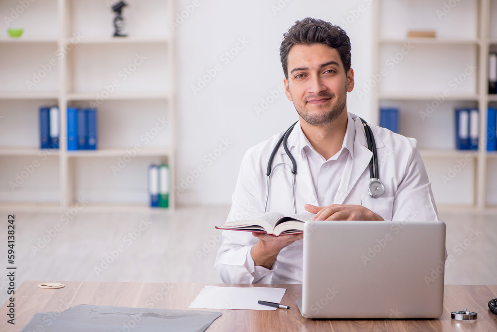 Young male doctor reading book