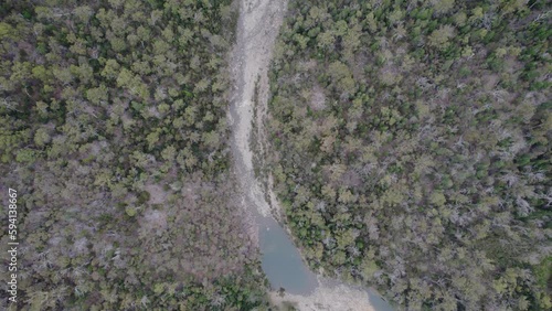 Apsley Gorge Waterhole And Exposed Riverbed Surrounded By Dense Forest In Douglas-Apsley, Tasmania. aerial tilt-up photo