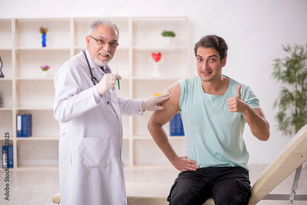 Obraz premium Young male patient visiting old male doctor in vaccination conce