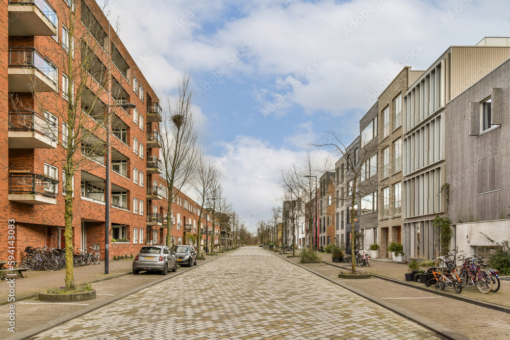 a city street with bikes parked on the sidewalks and buildings in the background, all lined up against each other bricked building a city street with bikes parked on the sidewalks and buildings in the background, all lined up against each other bricked building