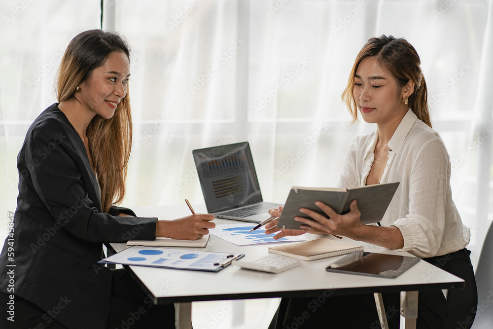 business woman making a presentation in front of colleagues Businesswoman consultant explaining financial charts in corporate group training with laptop and financial papers on table business woman making a presentation in front of colleagues Businesswoman consultant explaining financial charts in corporate group training with laptop and financial papers on table