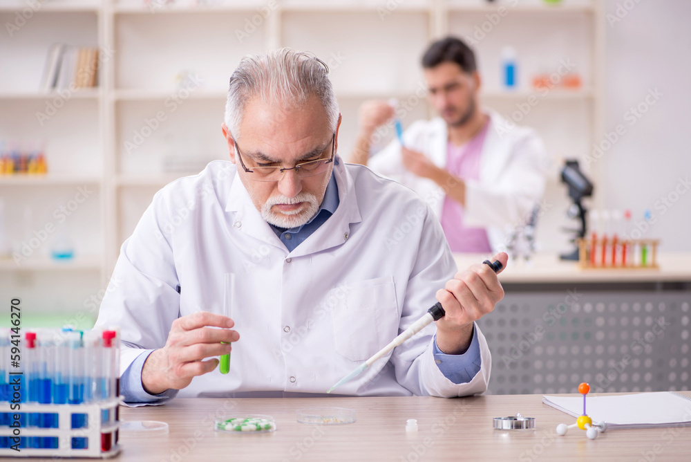 Two male chemists working at the lab Two male chemists working at the lab