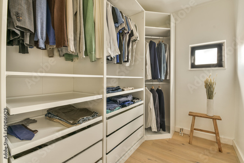 the inside of a walk - in closet with clothes hanging on shelves, and wooden flooring boards around it © Casa imágenes