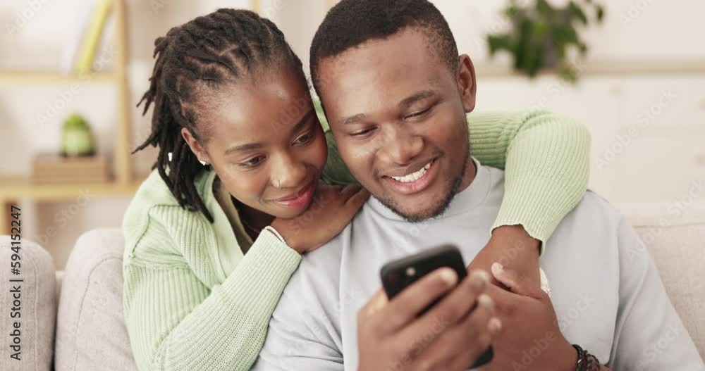 Phone, hug and happy black couple reading funny news, online story or blog post on home living room sofa. Bonding embrace, website and smiling man, woman or people enjoy relax quality time together Phone, hug and happy black couple reading funny news, online story or blog post on home living room sofa. Bonding embrace, website and smiling man, woman or people enjoy relax quality time together