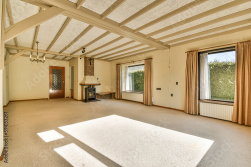 an empty living room with wood beams on the ceiling and large windows overlooking out onto the landscaped garden area