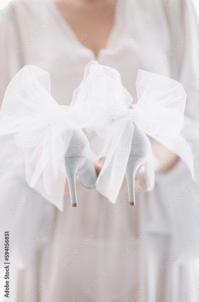 Delicate beautiful shoes of the bride with airy bows Delicate beautiful shoes of the bride with airy bows