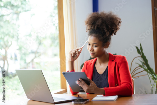 Business woman using tablet and laptop for doing math finance on an office desk, tax, report, accounting, statistics, and analytical research concept