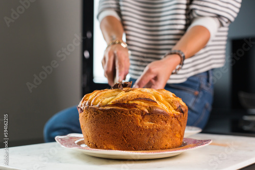 Woman cutting homemade apple pie at the kitchen