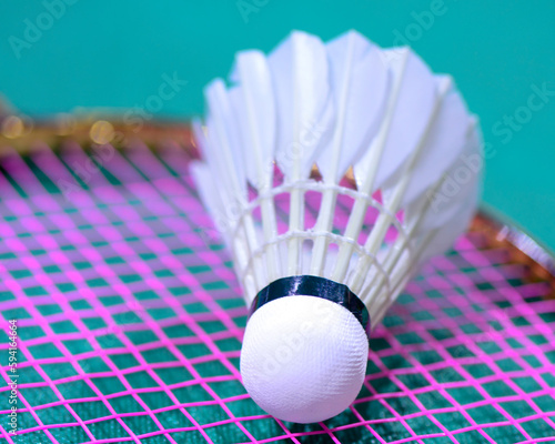 White cream badminton shuttlecock and badminton rackets on blue floor of indoor badminton court, soft and selective focus, concept for badminton sport lovers around the world © Iliya Mitskavets