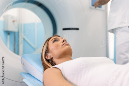 Female Patient Lying on a CT or PET or MRI Scan Bed, Moving Inside the Machine While it Scans Her Brain and Vital Parameters.