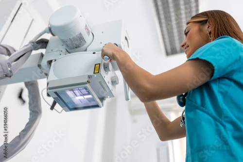 Photos Doctor looking at X-ray machine in clinic