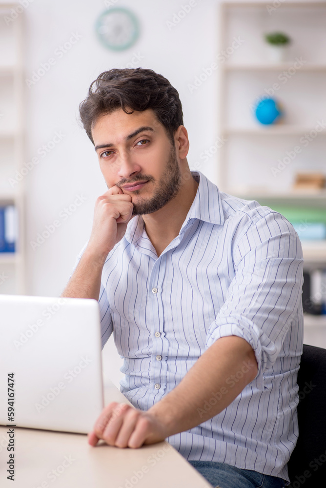 Young male employee working in the office Young male employee working in the office