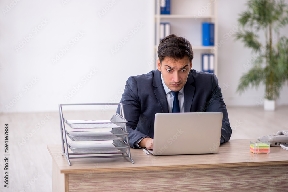 Young male employee working in the office Young male employee working in the office