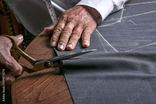 A tailor cutting a cloth according to the tradition of tailors. The dressmaker uses perfect needle and thread to sew traditional concepts, sewing