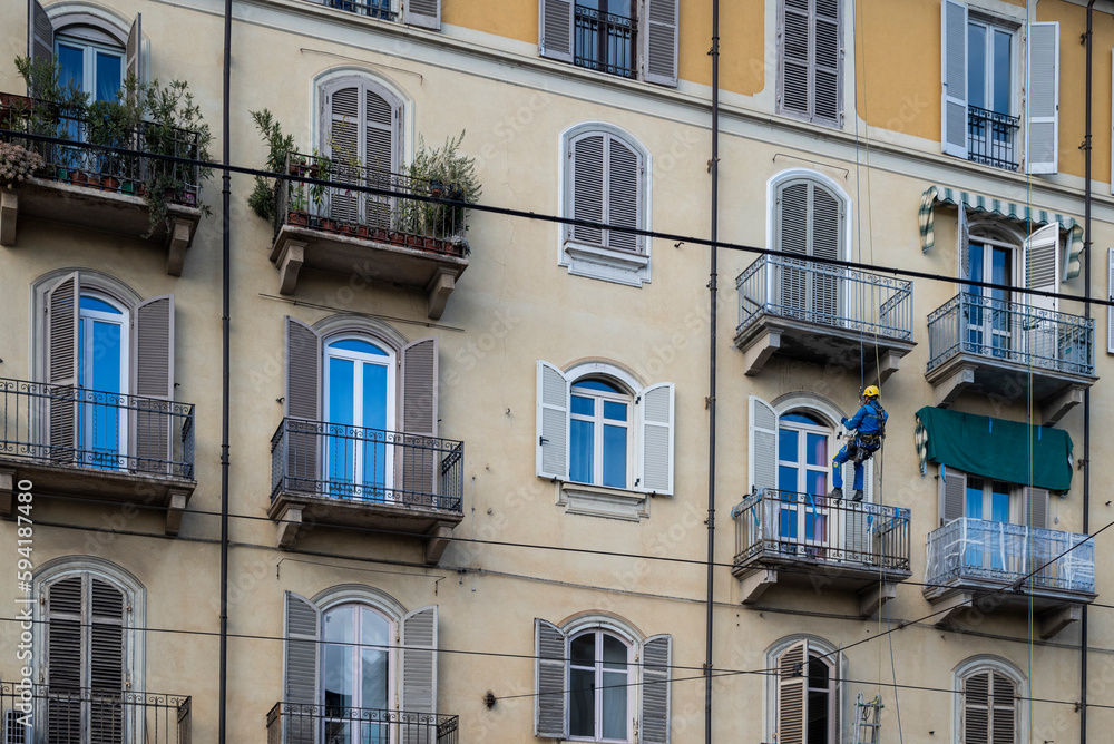 Edilizia acrobatica. Lavoratori con corde da scalata al lavoro per riparazioni e ristrutturazioni edifici.