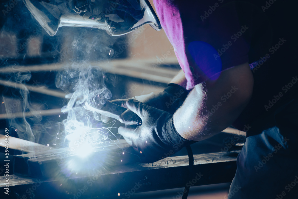 Industry worker welding iron pieces at work Industry worker welding iron pieces at work