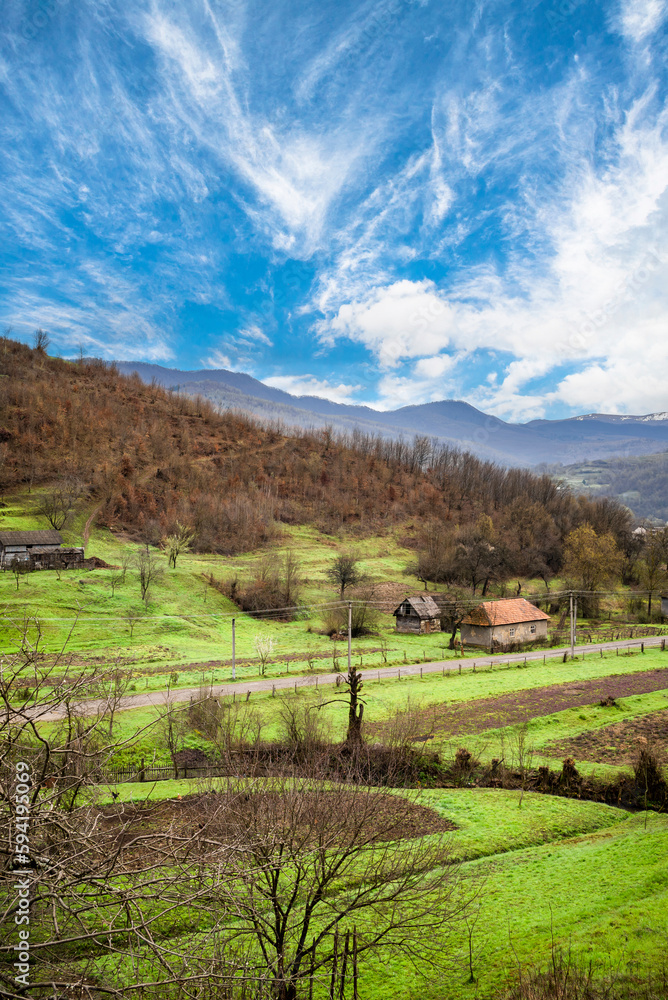 Mountain Village on a Sunny Summer day.Amazing view on a small village on the Mountains .Green valley with fields and villages among mountains. Mountain Village on a Sunny Summer day.Amazing view on a small village on the Mountains .Green valley with fields and villages among mountains.