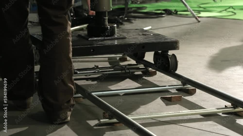 following closeup shot of a dolly being pushed along tracks forward and backward following closeup shot of a dolly being pushed along tracks forward and backward