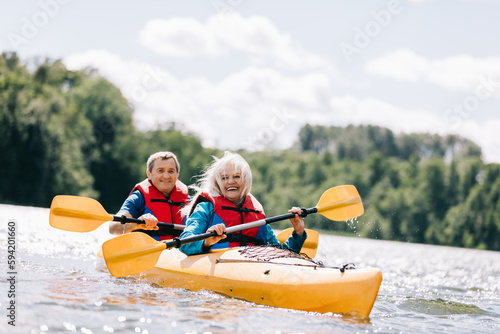 Canvas Print Happy senior active couple kayaking on lake
