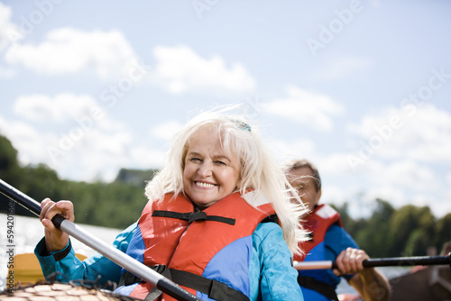 Happy senior active couple kayaking on lake