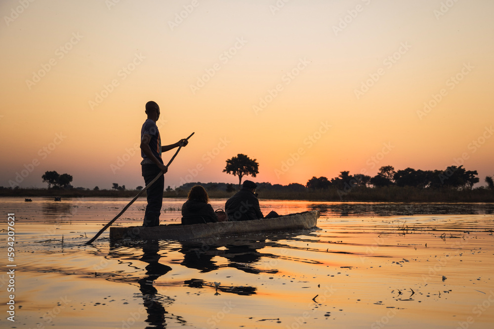 silhouette of a person in a mokoro boat