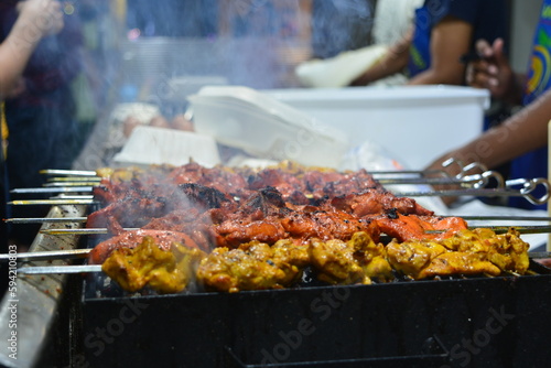 Street food marinated coal fire smoke grilled chicken skewers on metal skewers