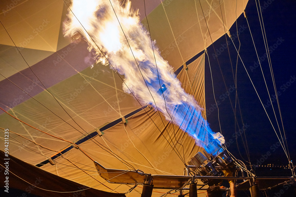Obraz premium Hot air balloon heater with flame at night. Ballooning