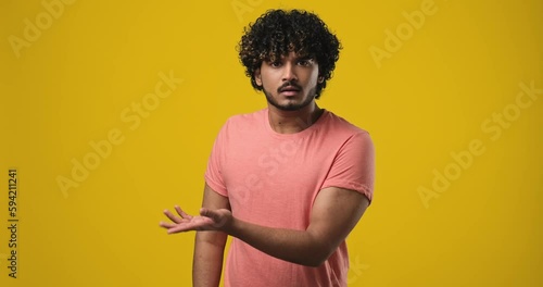 Confused Shocked Young indian man pointing with index finger to the side photo