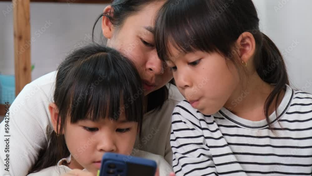 Mother and daughter playing and hugging, taking selfies on smartphones, watching cartoons or playing online games at home. Happy loving family and Mother's Day concept. Mother and daughter playing and hugging, taking selfies on smartphones, watching cartoons or playing online games at home. Happy loving family and Mother's Day concept.