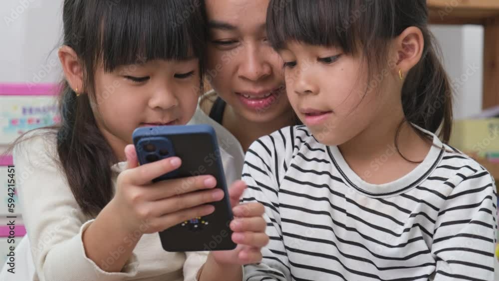 Mother and daughter playing and hugging, taking selfies on smartphones, watching cartoons or playing online games at home. Happy loving family and Mother's Day concept. Mother and daughter playing and hugging, taking selfies on smartphones, watching cartoons or playing online games at home. Happy loving family and Mother's Day concept.