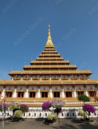 Flowering bushes in front of nine-story stupa Phra Mahathat Kaen Kakhon, Wat Nong Waeng Temple, Khon Kaen, Isan, Thailand, Asia photo