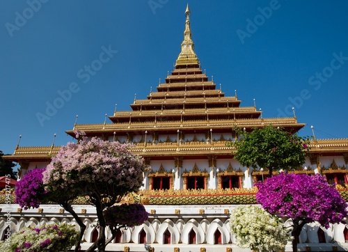 Flowering bushes in front of nine-story stupa Phra Mahathat Kaen Kakhon, Wat Nong Waeng Temple, Khon Kaen, Isan, Thailand, Asia photo