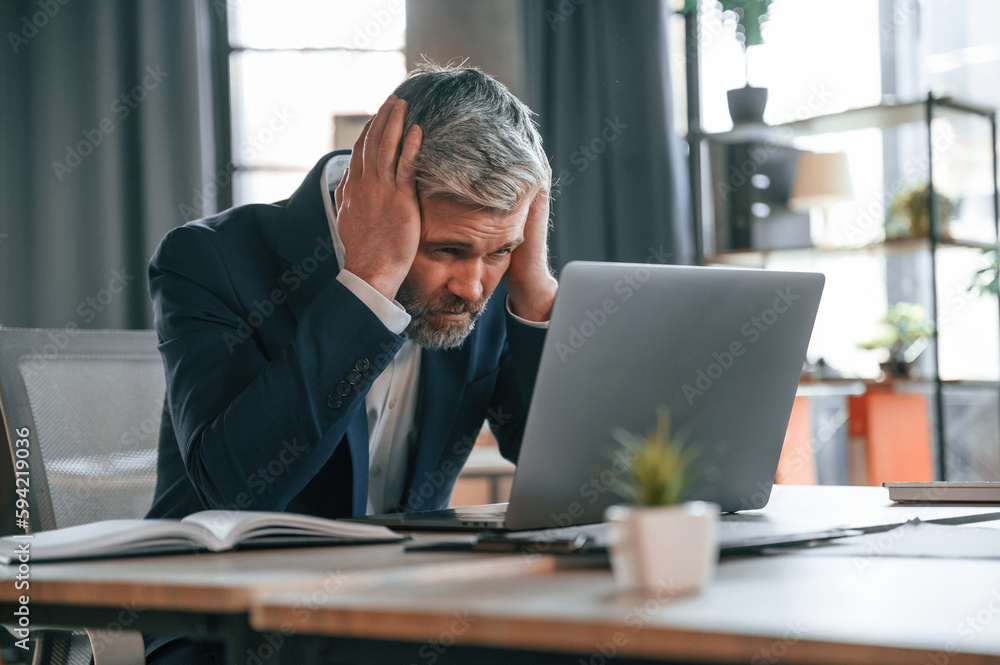 Feeling bad, tired, having headache, stressful. Senior businessman is working in the office Feeling bad, tired, having headache, stressful. Senior businessman is working in the office