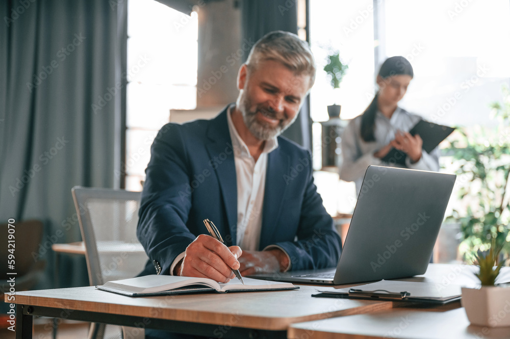 Senior man is with woman. Business people are working together in the office Senior man is with woman. Business people are working together in the office