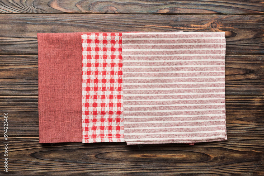 Obraz premium top view with red empty kitchen napkin isolated on table background. Folded cloth for mockup with copy space, Flat lay. Minimal style