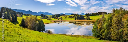 panoramic landscape with lake at springtime in front of mountain range