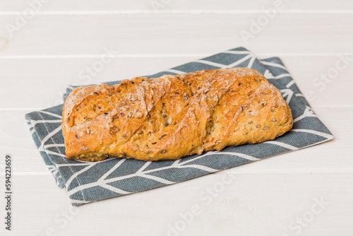 freshly baked bread with napkin on rustic table top view. Healthy white bread loaf isolated