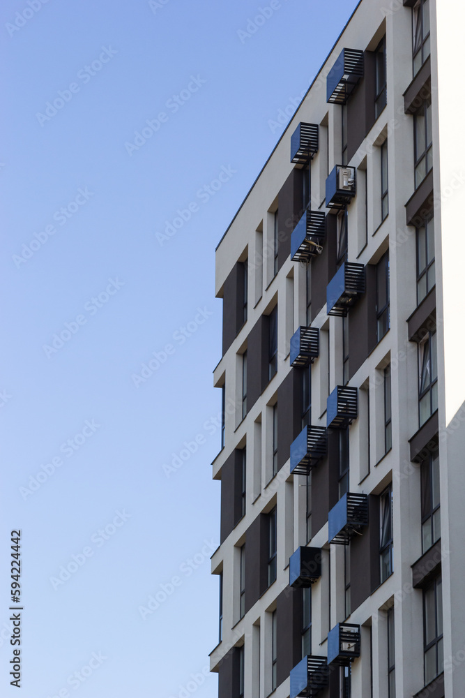 Architectural details of modern high apartment building facade with many windows and balconies